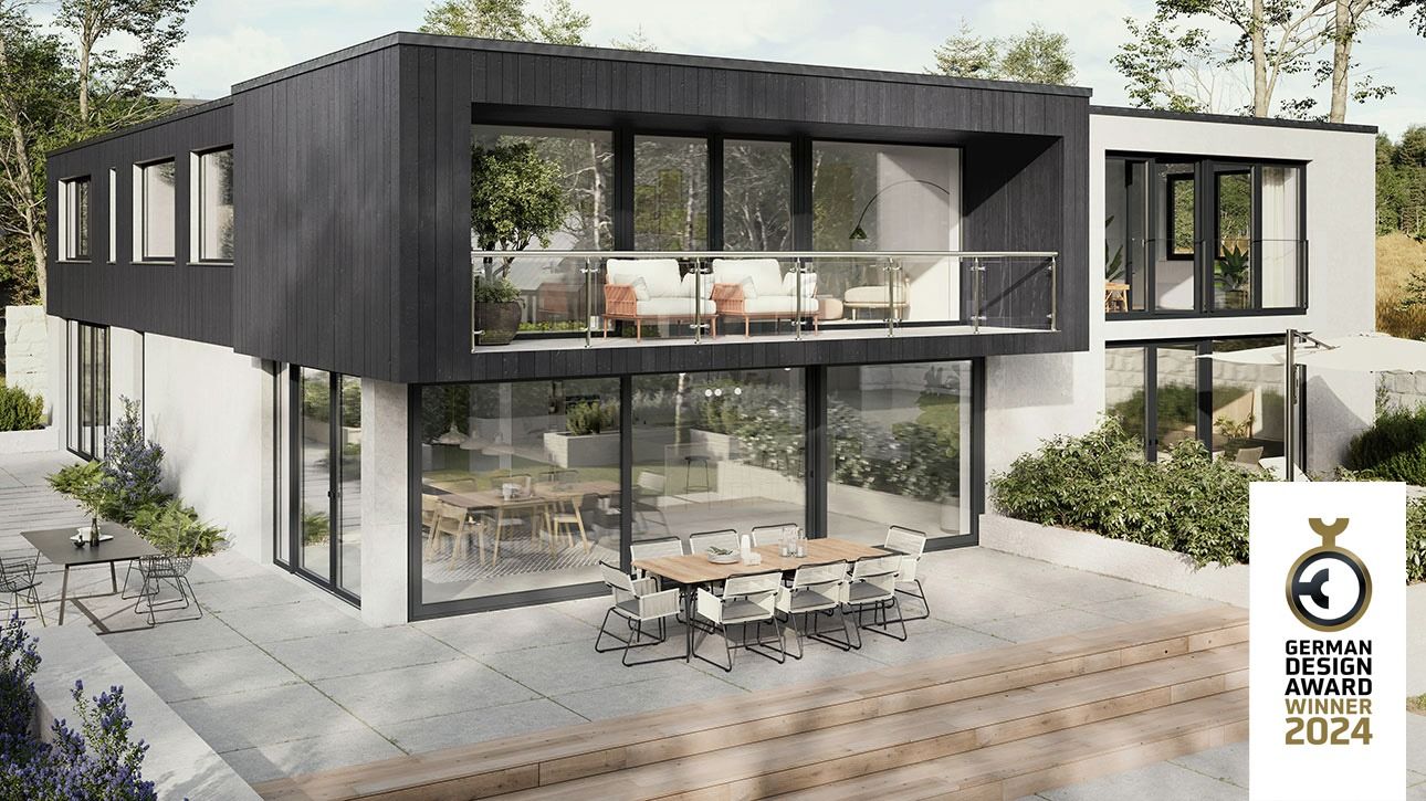 Modernes zweigeschossiges Haus mit großen Glasfronten, Terrasse mit Esstisch und Stühlen, umgeben von Bäumen